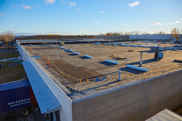 Ariel view of contractors getting ready to recover a commercial rooftop.