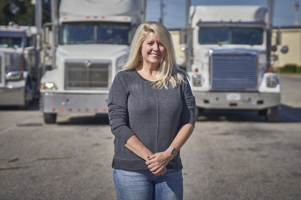 GAF female employee in front of trucks