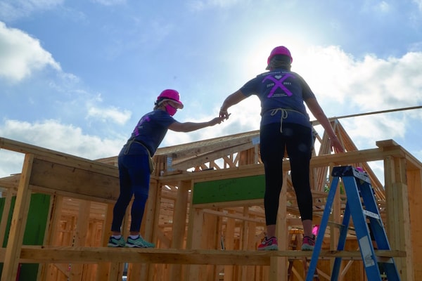 GAF team helping build a new home holding each other up.