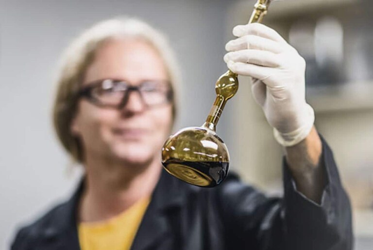 Female GAF scientist holding beaker with ansolution