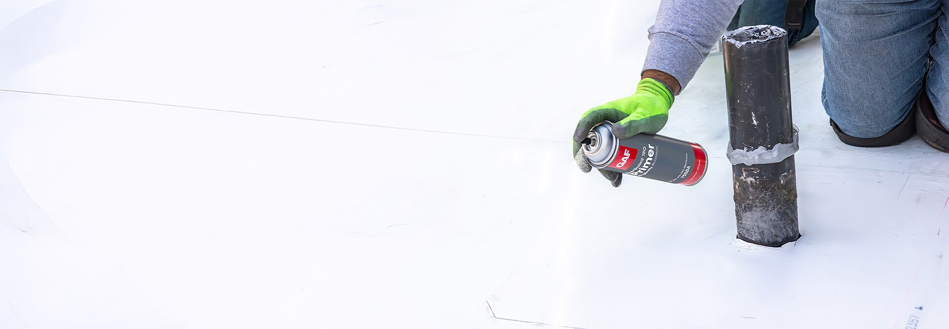 Close up of contractor spraying EverGuard® TPO Primer onto a commercial roof.