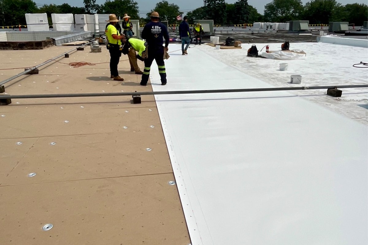 Certified contractors laying down GAF roofing materials on The New Interdisciplinary School