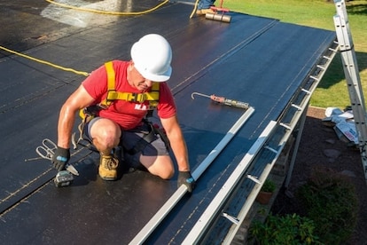 Contractor applying LIBERTY Flashing Cement on exposed roof flange.