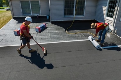 GAF roofing contractors installing LIBERTY SBS Self-Adhering Cap Sheet on a flat roof.