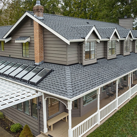 Beige home with a gray roof featuring new GAF Timberline UHDZ shingles.