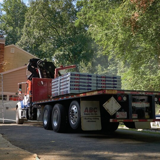 Tractor with a load of GAF roofing shingles.