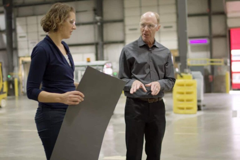 Male and female roofing science team members in warehouse