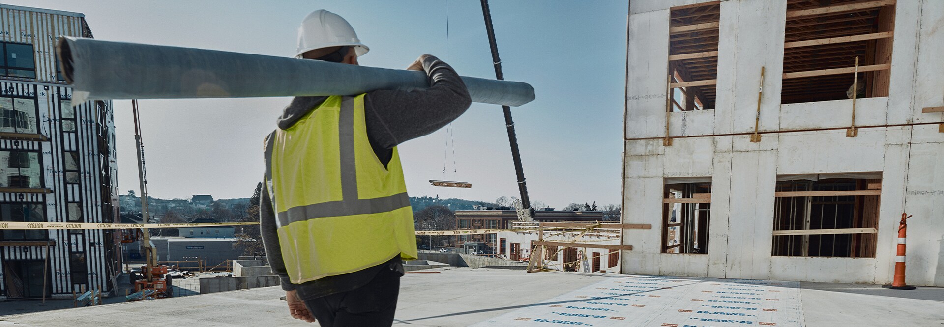 Contractor holding roofing materials walking on the roof of the Revington