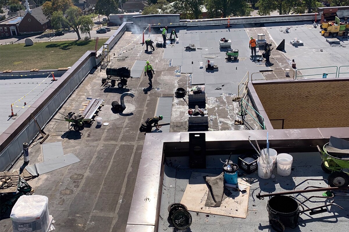 Certified contractors laying down GAF roofing materials on NorthEast Middle School