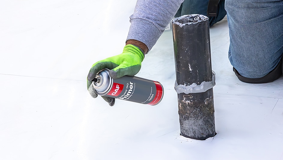 Close up of contractor spraying EverGuard® TPO Primer onto a commercial roof.